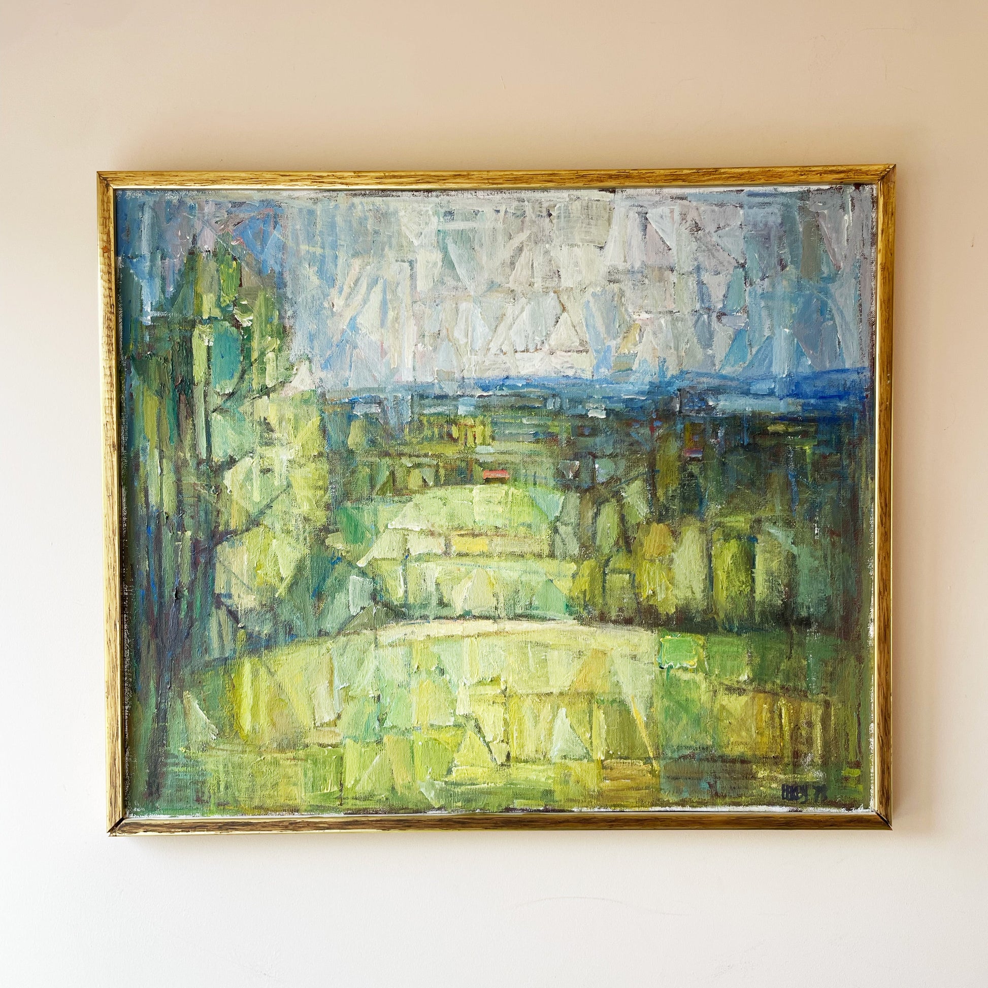 Mid-century modern cubist landscape oil painting in gold frame, signed and dated '75, depicting a fragmented green countryside scene with faceted trees, fields, and abstract sky in blue, white, and yellow tones — original vintage fine art for sale.