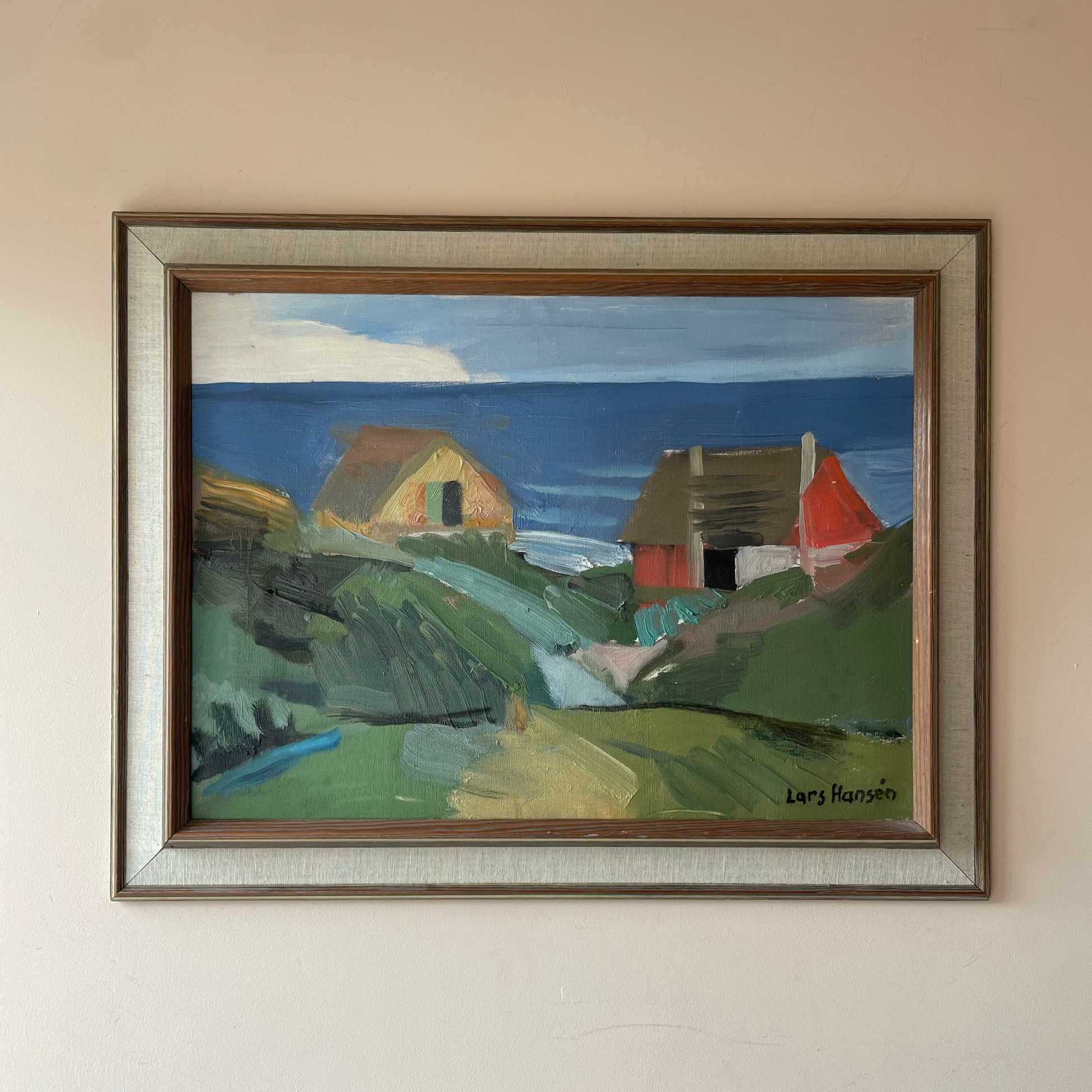 Original mid century Scandinavian coastal oil painting signed Lars Hansén. Cottages above a blue sea in a linen slip frame. Free UK delivery.