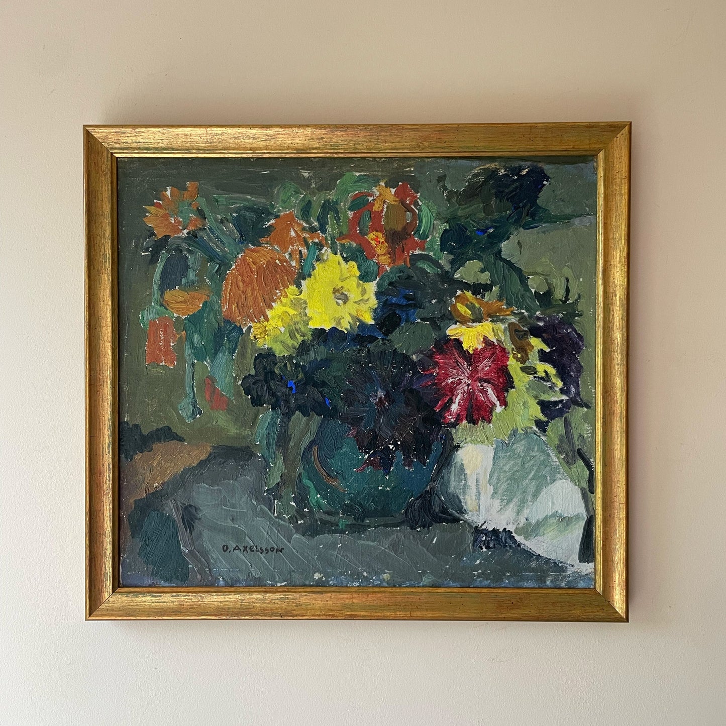 Framed painting of a floral arrangement on a beige wall