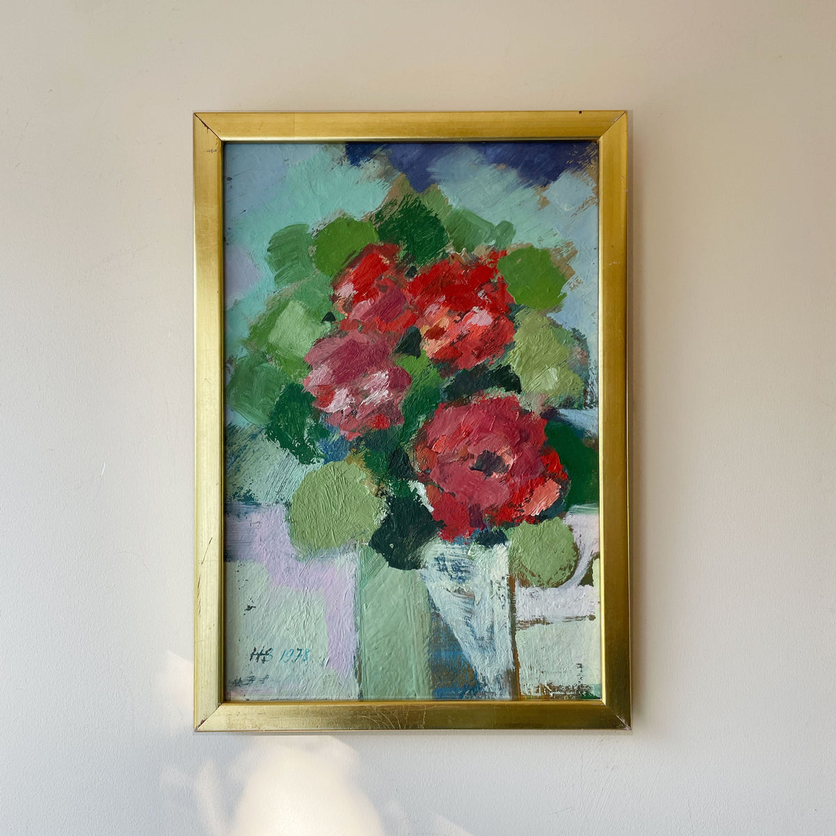 Vintage floral still life oil painting of red roses in a white vase against a turquoise and green background, thick impasto brushwork, in a gold frame, monogram signed and dated 1978.