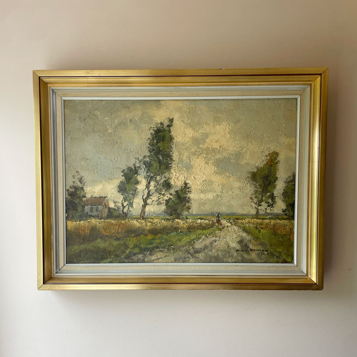 Oil painting of a figure walking a country lane between summer fields, with a farmhouse and wind-bent trees under a cloudy sky, in a gilt frame