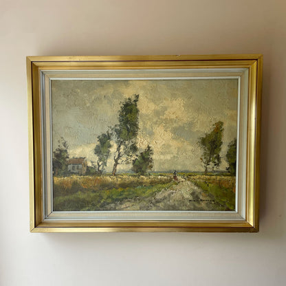 Oil painting of a figure walking a country lane between summer fields, with a farmhouse and wind-bent trees under a cloudy sky, in a gilt frame