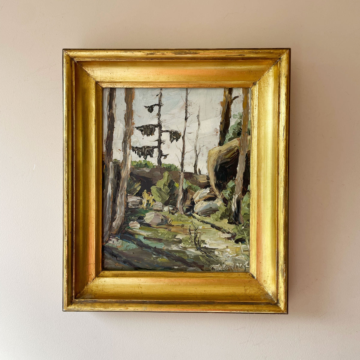 Vintage impasto oil painting of a pine forest clearing with boulders in a gilt frame