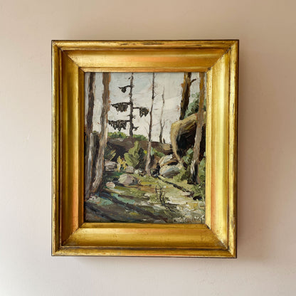 Vintage impasto oil painting of a pine forest clearing with boulders in a gilt frame